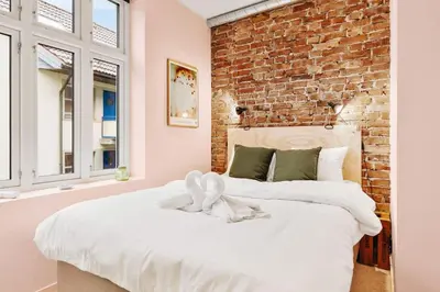 a bedroom with two beds and a brick wall at DINBNB Apartments Private terrace l 700 m to Bryggen l Modern in Bergen