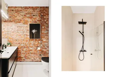 a bathroom with a shower and a brick wall at DINBNB Apartments Private terrace l 700 m to Bryggen l Modern in Bergen