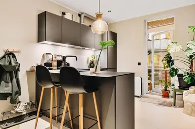 a kitchen with a counter and two chairs at a bar at DINBNB Apartments Private terrace l 700 m to Bryggen l Modern in Bergen