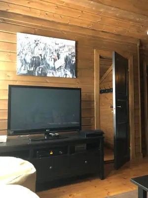 a living room with a flat screen tv on a wall at Wonderful Ski-In, ski-out Cabin at Kvitfjell in Strande