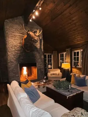 a living room with a fireplace with a bull head on the wall at Wonderful Ski-In, ski-out Cabin at Kvitfjell in Strande