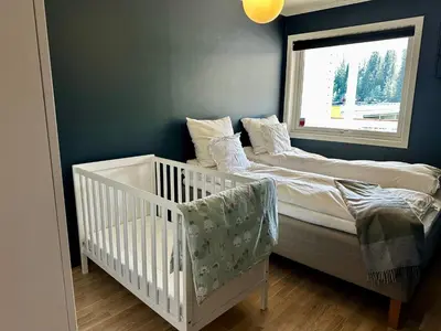 a baby room with two beds and a window at Granåsen ski-VM in Trondheim