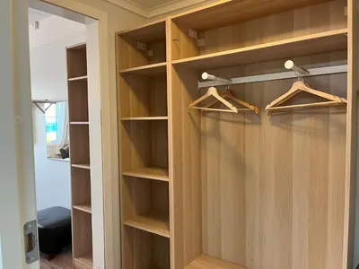 a closet with wooden shelves and a door at Bitihorn fjellbris in Beitostøl