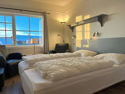 a hotel room with three beds and a window at Bitihorn fjelltind in Beitostøl