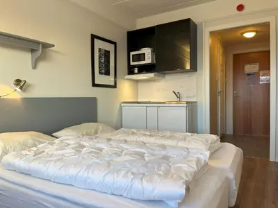 a large bed in a room with a kitchen at Bitihorn fjelltind in Beitostøl