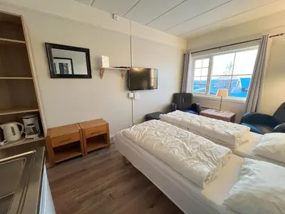 a hotel room with two beds and a tv at Bitihorn fjelltind in Beitostøl