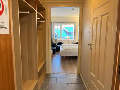 a hallway leading to a room with a bed and a bedroom at Bitihorn fjelltind in Beitostøl