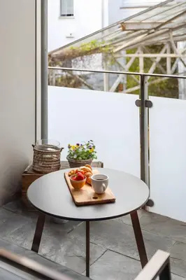 a table with a plate of fruit on a balcony at Modern and chic city apartment - Bergen City in Bergen