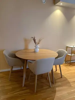 a wooden table with chairs and a vase on it at Modern and chic city apartment - Bergen City in Bergen