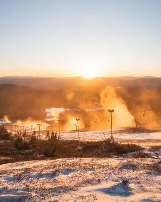 a snow covered field with the sun in the background at Norefjell! Newly built cabin with stunning view in Noresund