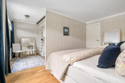 a bedroom with a bed and a table and a chair at Spacious and Peaceful Home with a Private Gym in Trondheim