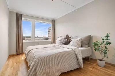 a white bedroom with a bed and a window at Spacious and Peaceful Home with a Private Gym in Trondheim