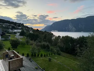 a view of a lake and mountains with a house at FjordView in Stranda