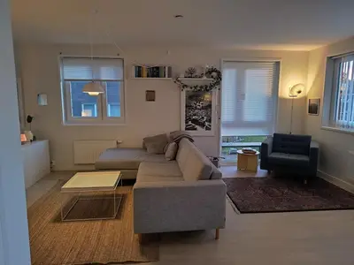 a living room with a couch and a chair at Romslig og pen leilighet - sentral beliggenhet in Charlottenlund