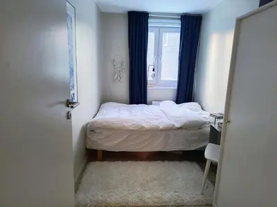 a small bedroom with a bed and a window at Romslig og pen leilighet - sentral beliggenhet in Charlottenlund