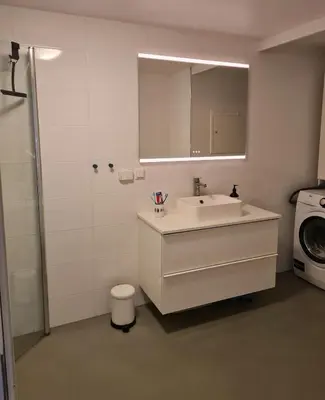 a bathroom with a sink and a washing machine at Romslig og pen leilighet - sentral beliggenhet in Charlottenlund
