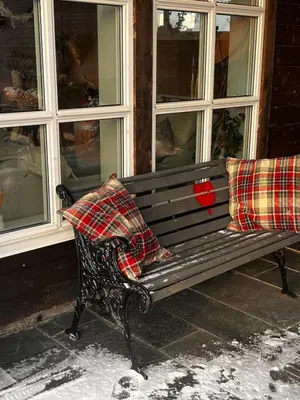 a bench with two pillows sitting in front of a building at Fairy tale house during Ski world cup in Melhus