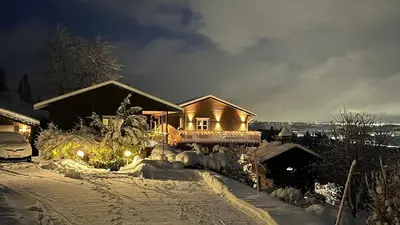 a house covered in snow at night with lights at Fairy tale house during Ski world cup in Melhus