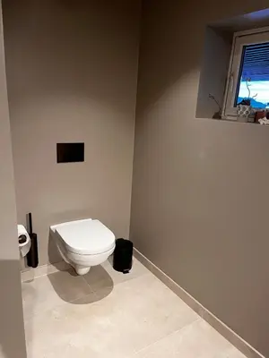 a bathroom with a white toilet and a window at Fairy tale house during Ski world cup in Melhus