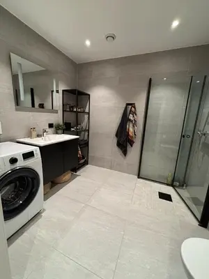 a bathroom with a washing machine and a sink at Modern Appartement - Ski World Cup 2025 in Trondheim
