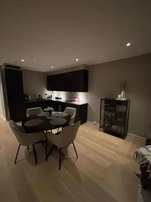 a living room with a table and chairs and a kitchen at Modern Appartement - Ski World Cup 2025 in Trondheim