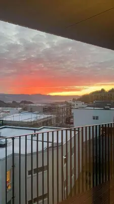 a view of a sunset from the balcony of a building at Modern Appartement - Ski World Cup 2025 in Trondheim
