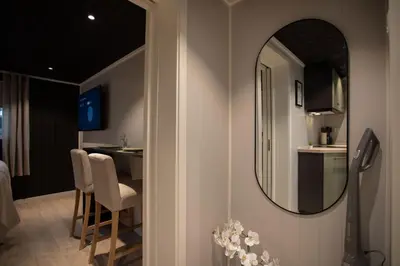 a living room with a mirror and a table at Studio Plassen in Sogndal