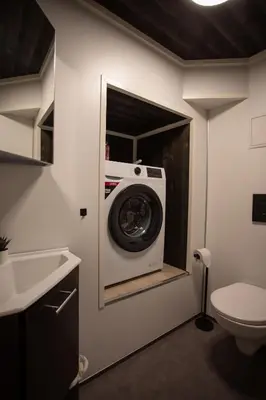 a washing machine in a bathroom with a toilet at Studio Plassen in Sogndal