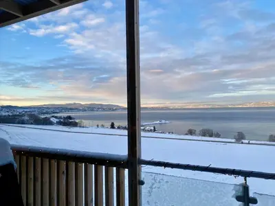a view of the water from a balcony with snow at Hus til leie under VM 2025 in Trondheim