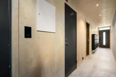 a hallway with a black door and a sign on a wall at Architectural Studio I Private Balcony in Bergen