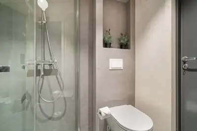 a bathroom with a shower with a toilet and a glass shower stall at Architectural Studio I Private Balcony in Bergen