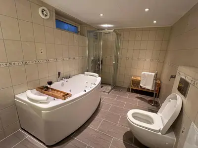 a bathroom with a tub and a toilet and a shower at World championship ski 2025-Cozy house for rent in Trondheim