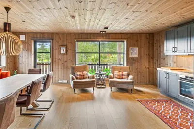 a kitchen with wood paneling and a table and chairs at Very central and fresh apartment 4 bedr, 10p 2 floors, sauna, ski in and out in Trysil