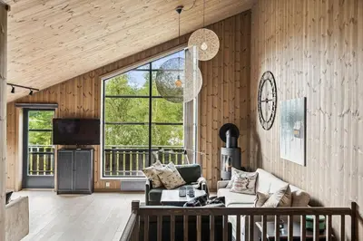 a living room with a couch and a large window at Very central and fresh apartment 4 bedr, 10p 2 floors, sauna, ski in and out in Trysil