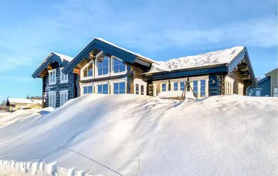 a house with a pile of snow in front of it at Stunninng Home In Rauland With Sauna in Rauland