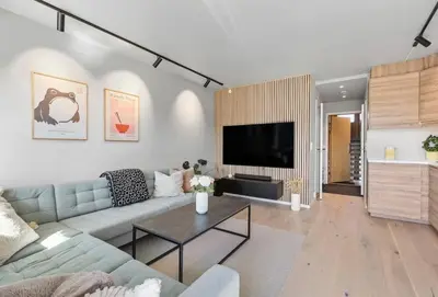 a living room with a couch and a tv at Lys og koselig leilighet in Trondheim