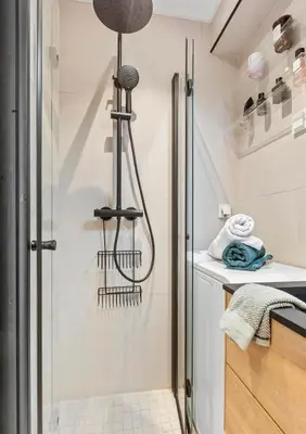 a shower in a small bathroom with a sink at Lys og koselig leilighet in Trondheim