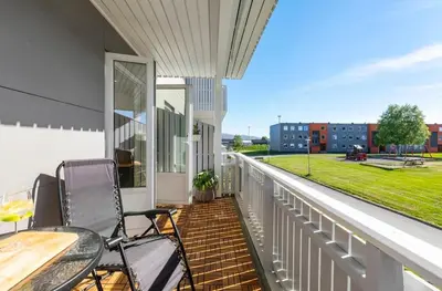 a balcony with two chairs and a table on it at Lys og koselig leilighet in Trondheim