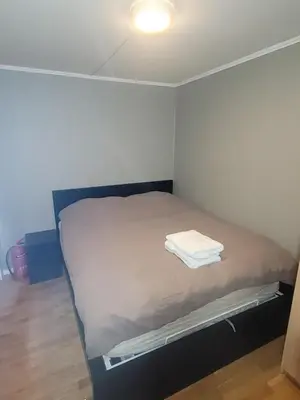a small bedroom with a bed with a light on it at Koselig leilighet på Møllenberg in Trondheim