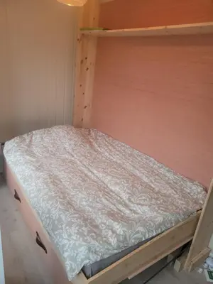 a bed in a bed frame in a room at Koselig leilighet på Møllenberg in Trondheim
