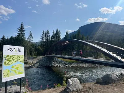 a bridge over a river with two people riding bikes at Hemsedal, sengeplass til 8, ski inn ski out in Hemsedal