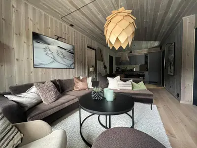 a living room with a couch and a table at Hemsedal, sengeplass til 8, ski inn ski out in Hemsedal