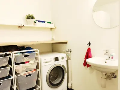 a bathroom with a washing machine and a sink at Townhouse in quiet and central area with free parking in Trondheim