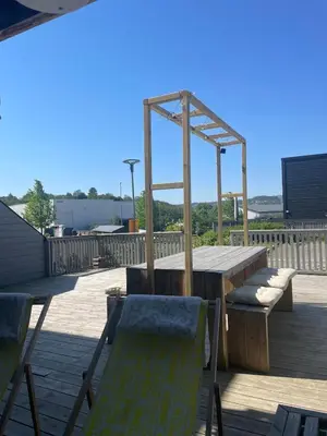 a wooden table and chairs on a deck at Townhouse in quiet and central area with free parking in Trondheim