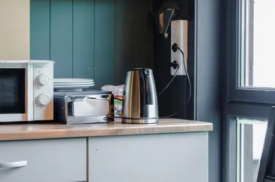 a kitchen counter with a coffee maker and a microwave at Bergmannshuset in Løkken