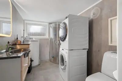 a kitchen with a washing machine and a sink at Koselig lelighet in Trondheim