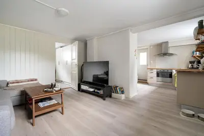a living room with a couch and a tv and a table at Koselig lelighet in Trondheim