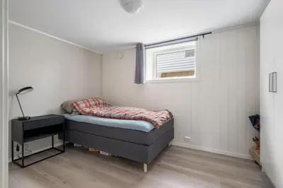 a small bedroom with a bed and a window at Koselig lelighet in Trondheim