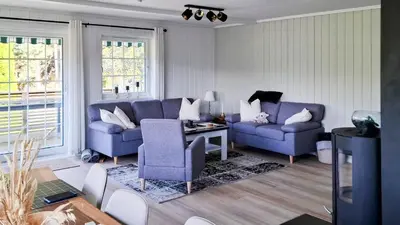 a living room with two blue chairs and a table at ThePearl in Sel
