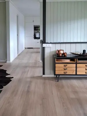 a kitchen with white cabinets and a wood floor at ThePearl in Sel